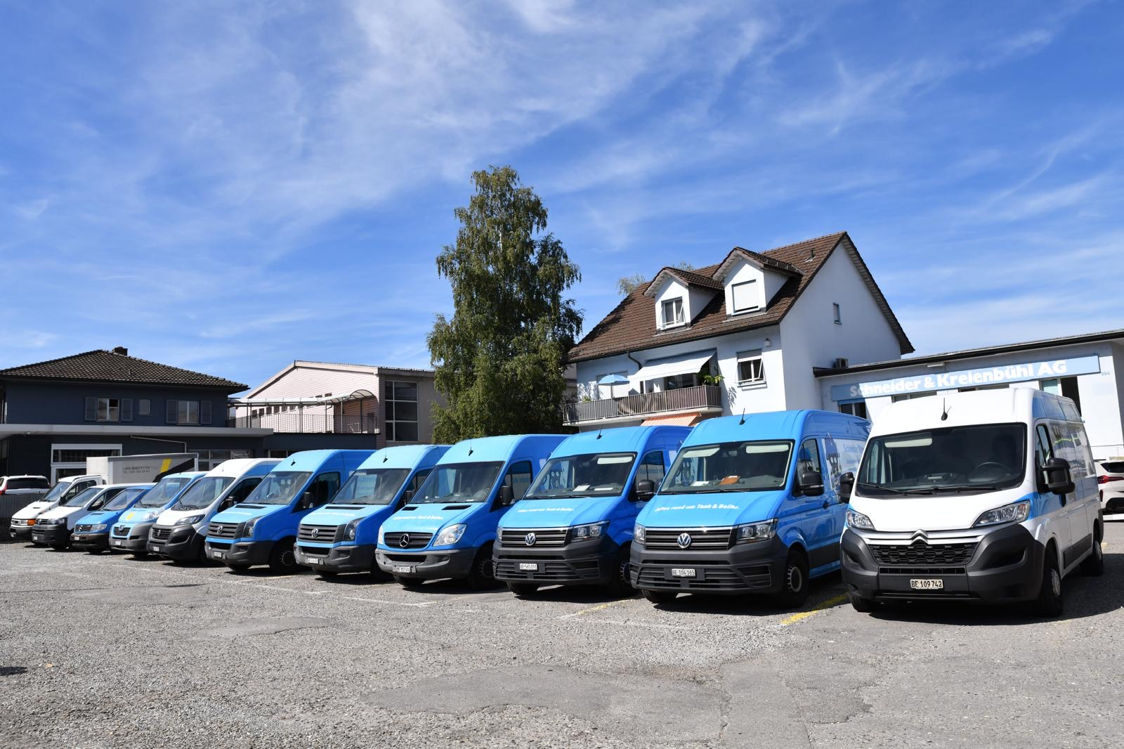 Fahrzeugflotte der Schneider Kreienbühl AG vor dem Firmengebäude